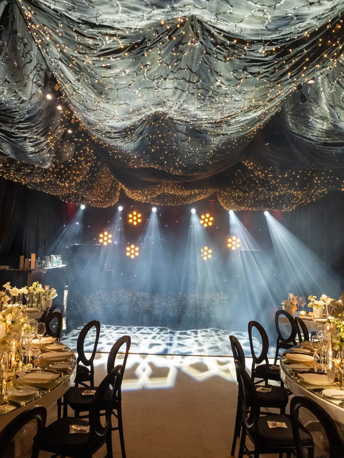 Espace événementiel premium avec installation lumineuse scintillante et tables dressées