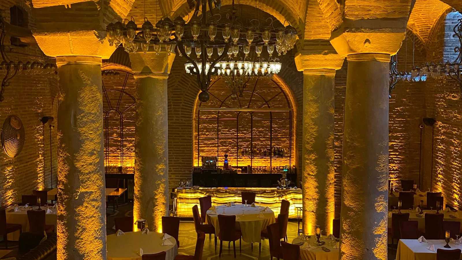 Intérieur premium aux arches chaleureuses, image d’ambiance d’une orientation hospitality possible pour shezan.be